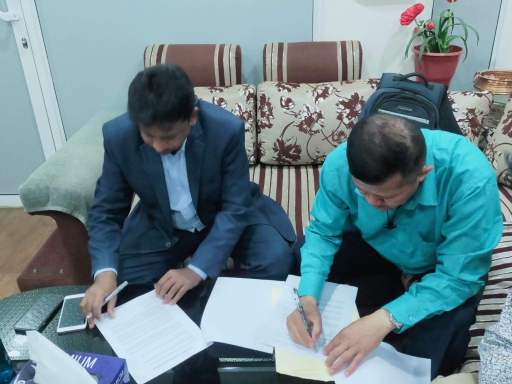 Agreement papers being signed during a bilateral meeting.
